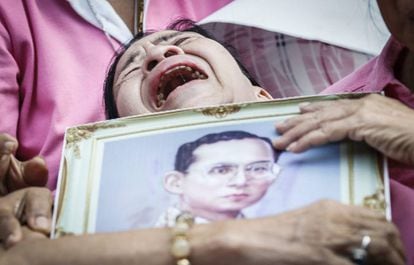 Una mujer llora abrazada a un retrato del rey Bhumibol Adulyadej tras conocer su fallecimiento, en Bangkok (Tailandia).