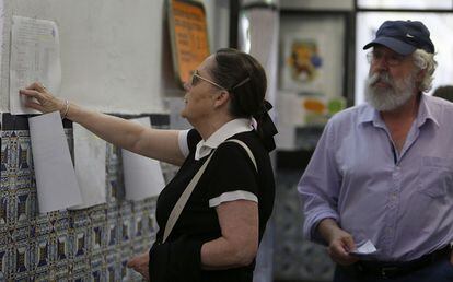 Una mujer consulta la lista del censo en un colegio electoral de Valencia.