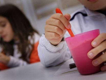 Dos ni&ntilde;os de una familia vulnerable toman la merienda en un local de la Cruz Roja en Sabadell