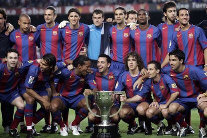 El equipo del FC Barcelona posa con el trofeo que lo acredita como vencedor del título de liga 2004-2005, antes del inicio del partido de la penúltima jornada, contra el Villarreal. De izquierda a derecha, fila de arriba: Albertini (parcialmente visible), Larsson, Motta, Edmilson, Jorquera, Márquez, Eto'o, Oleguer y Belletti. Fila de abajo: Iniesta, Gio Van Bronckhorst, Ronaldinho, Xavi, Puyol, Giuly y Deco.  