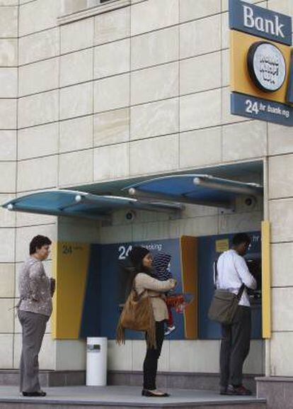 Varias personas ayer esperan en un cajero para retirar efectivo en una sucursal del banco chipriota ATM en Nicosia (Chipre).