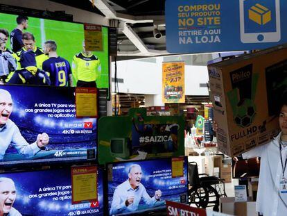 Un empleado carga un televisor en una tienda de productos electrónicos, en Sao Paulo.