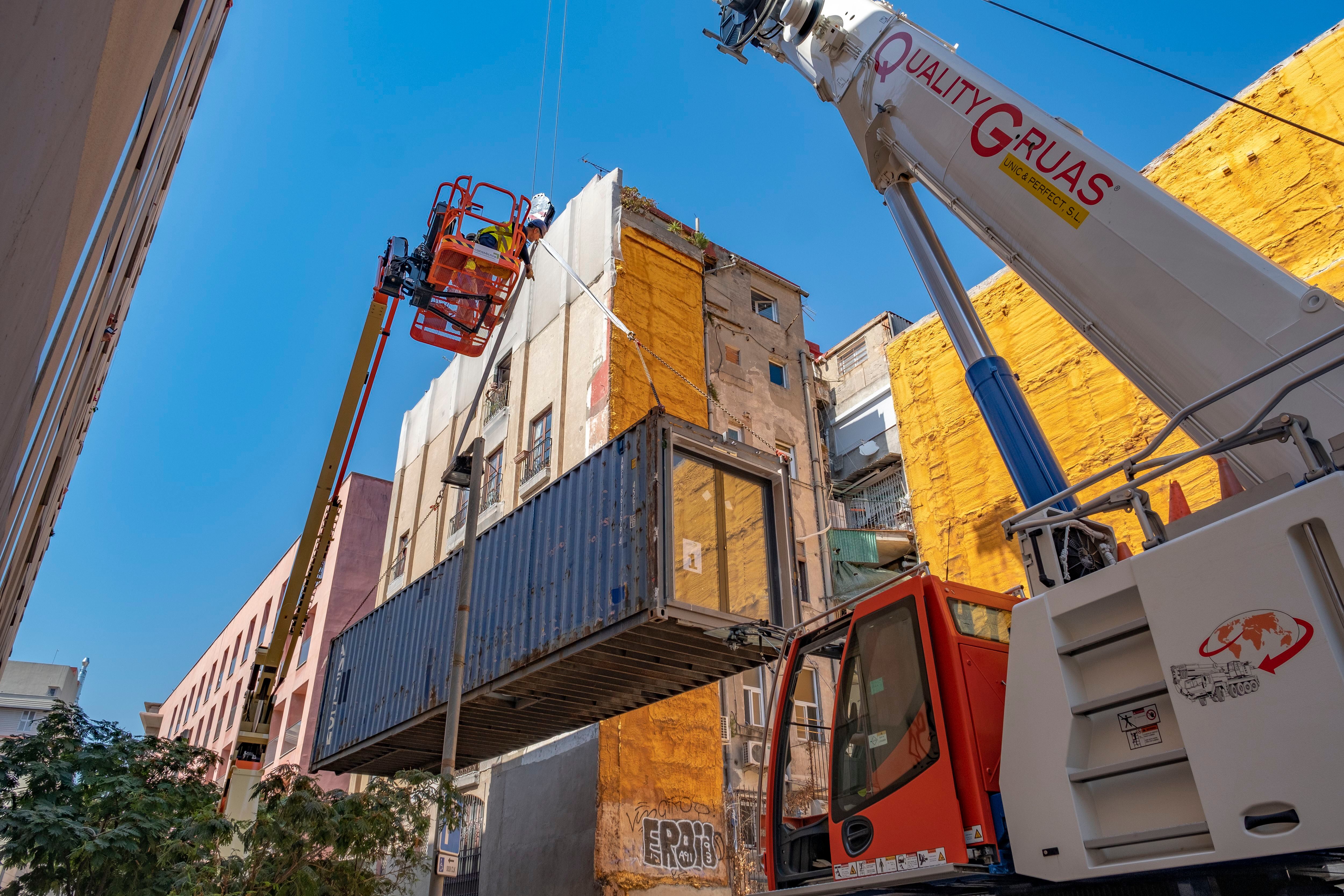 Una grúa coloca un contenedor en uno de los edificios hechos con contenedores en Barcelona, en una imagen de 2019. 