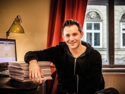 Max Schrems, en su apartamento de Viena, apoyado sobre las 1.200 hojas de información personal que Facebook recopiló sobre él.