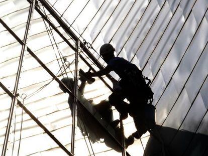 Un operario saca lustre a la fachada del museo Guggenheim de Bilbao