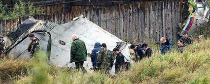 Miembros de un equipo de investigación inspeccionan los restos del avión que se estrelló en los Urales.