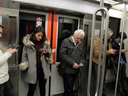 Viajeros del Metro de Bilbao consultan sus móviles.