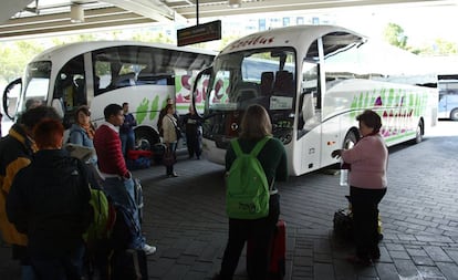 Varios pasajeros en las dársenas de la Estacion Sur de Autobuses de Madrid.