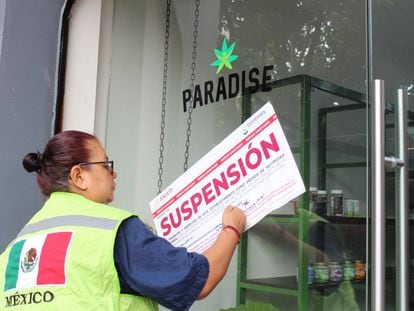 Una inspectora de la Cofepris coloca un sello de suspension en la entrada de una tienda Paradise, en el centro de Ciudad de México.