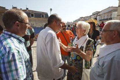 El diputado general de Gipuzkoa, Martín Garitano (centro), y el alcalde de San Sebatián, Juan Carlos Izaguirre (izquierda), saludan a representantes de la asociación de familiares de presos de ETA Etxerat invitados al inicio de las fiestas de Vitoria.