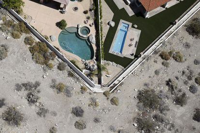 Los ayuntamientos tendrán que asegurarse de cumplir objetivos como incentivar la sustitución del césped por otros jardines, impedir el riego innecesario e incentivar la sustitución de fontanería antigua por otra que gaste menos. En la imagen, unas piscinas privadas junto a un campo seco en la zona de Palm Springs, California, el 13 de abril de 2015.
