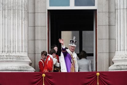 Carlos III saluda al público congregado en los alrededores de Buckingham mientras abandona el balcón. Miles de personas han aguantado bajo la lluvia para poder presenciar uno de los momentos más esperados de la jornada.