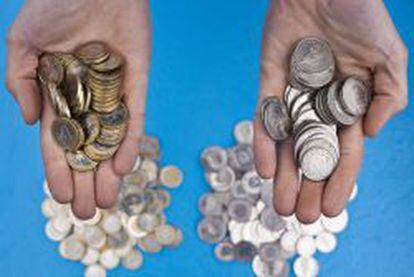 En la imagen, una persona sosteniendo en sus manos monedas de euro (izq) y monedas de franco suizo, en Zurich (Suiza). 