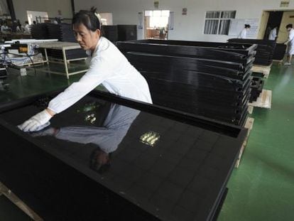 Una empleada limpia paneles solares reci&eacute;n fabricados en la ciudad china de Hefei.