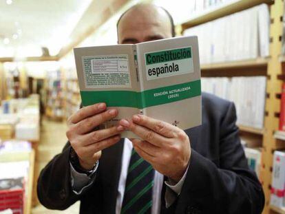 Un hombre lee la Constitución española en una librería.