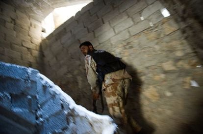 Un rebelde avanza por un edificio en el barrio de Saladino.