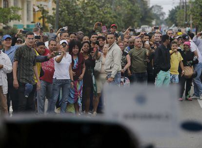 Ciudadanos de Cuba esperan en el borde de la carretera al coche de Obama, camino al primer encuentro con el presidente Raul Castro.