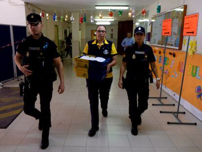 Dos policías escoltan a una funcionaria de Correos que traslada votos a una mesa electoral de Melilla en las pasadas elecciones municipales.