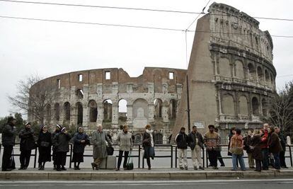 Varias personas hacen cola en una parada de autob&uacute;s junto al Coliseo romano. / Cristobal Manuel