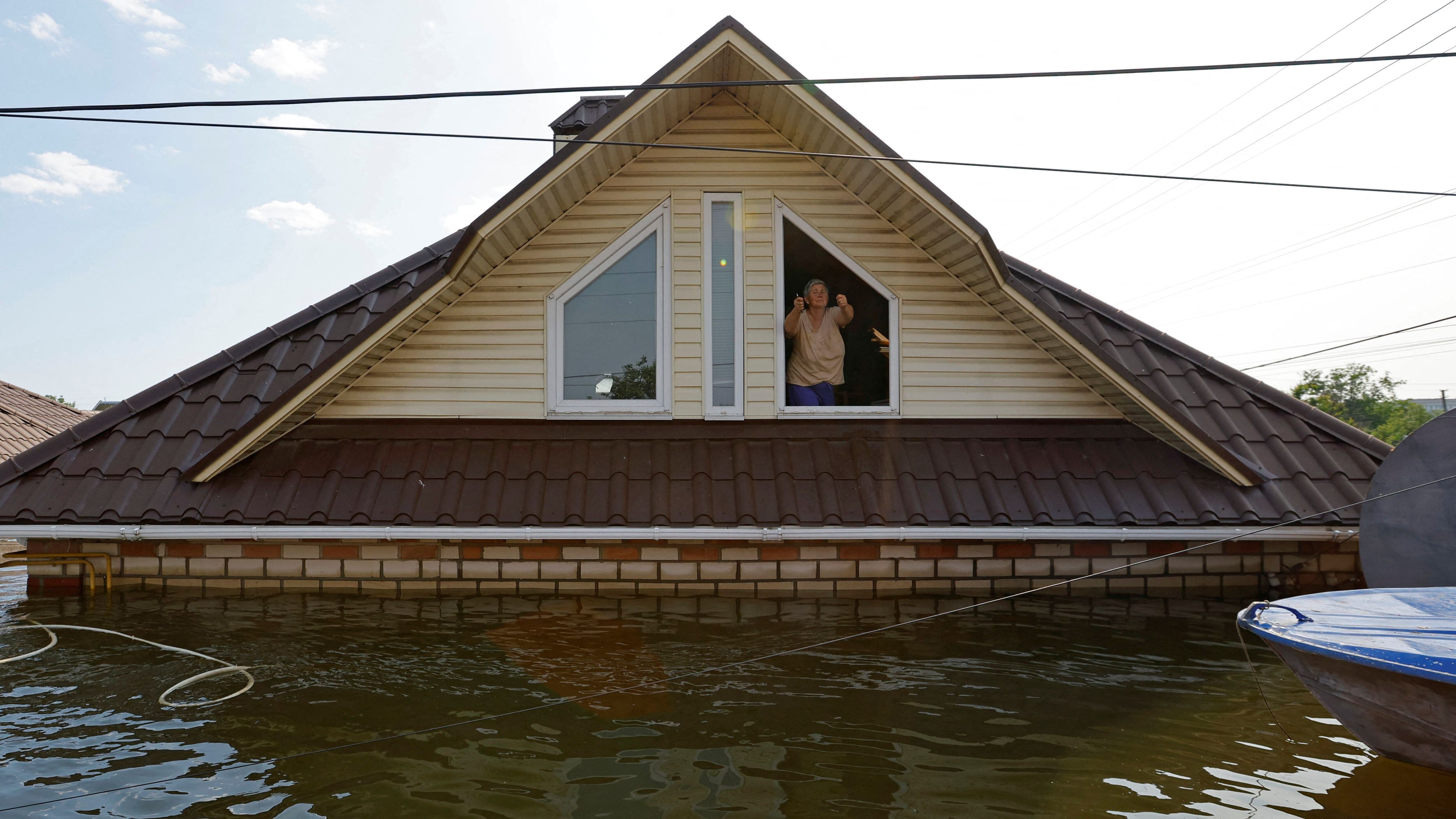 Una mujer, en el interior de su vivienda inundada en Nova Kakhovka, este jueves. 
