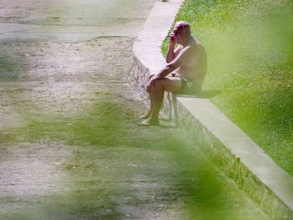Un hombre toma el sol en la piscina pública de Oira, en Ourense. 