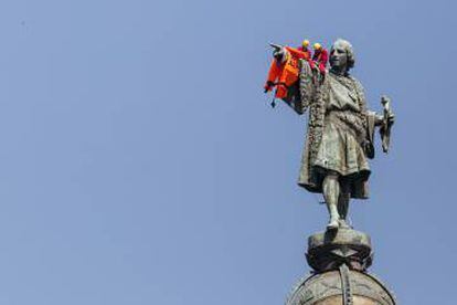 Activistes d'Open Arms col·loquen una armilla salvavides a l'estàtua de Colom.