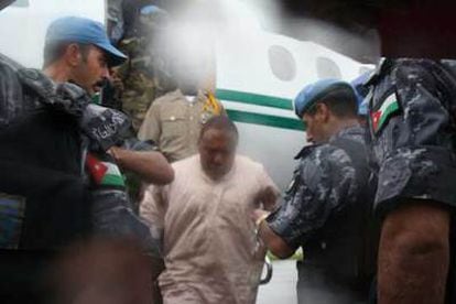 Soldados de la ONU detienen a Charles Taylor (de blanco) nada más descender del avión en el que llegó a Liberia.