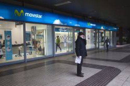 Una persona habla por el m&oacute;vil frente a una tienda de Movistar.