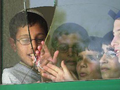 Unos niños israelíes, ante la ventana rota en su escuela por uno de los obuses palestinos.
