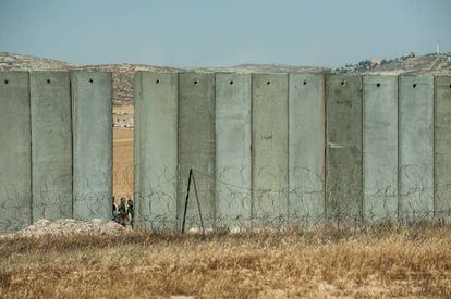 <a href="http://elpais.com/elpais/2017/05/31/album/1496247003_088581.html"><b>FOTOGALERÍA:</B></A> Palestinos cruzando la parte aún abierta del muro de Cisjordania, en Yata.