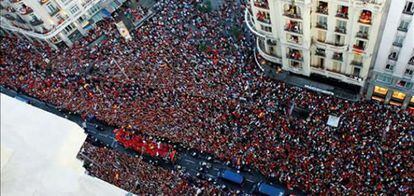 Miles de aficionados saludan a los jugadores de la selección española de fútbol a su paso por la Gran Vía madrileña