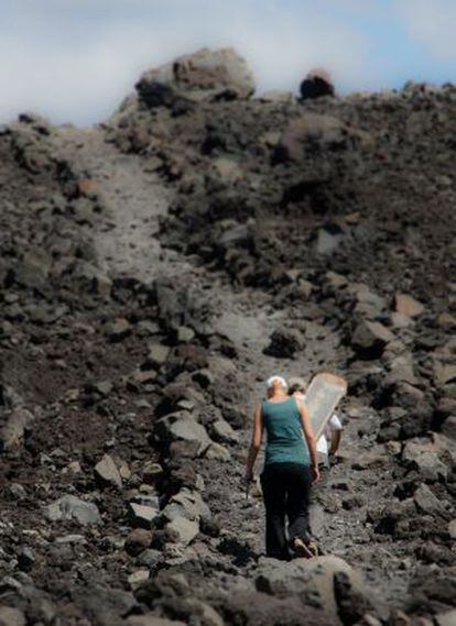 Dos turistas escalan el volcán Cerro Negro.