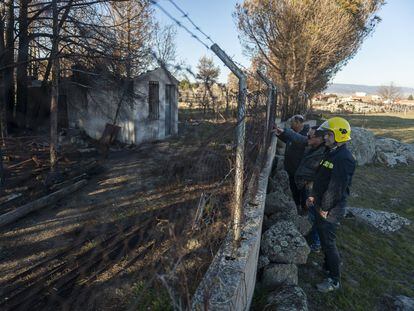 El ganadero Jesús Baterna, de Robledillo, enseña a los bomberos Juan Carlos Prieto y Juan Ignacio García, una caseta que arrasó el incendio.