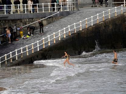 Dos personas se bañan en la playa de San Lorenzo, el miércoles en Gijón.