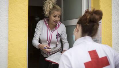 Cristina, voluntària de Creu Roja, porta menjar a Yoslen Garrido, al barrio de Nou Barris. 