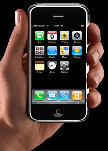 Apple anunció el iPhone en 2007, tras varios rumores y especulaciones. Salió en un primer lugar en EE UU como un smartphone de gama alta multimedia con conexión a Internet, con pantalla táctil y sin teclado físico. Dio un paso más e incorporó una cámara de fotos de dos megapixeles y un reproductor de música equivalente al del iPod. El iPhone fue un nuevo y revolucionario teléfono móvil que permitió a los usuarios hacer llamadas con sólo señalar un nombre o un número. El iPhone empezó a sincronizar todos los contactos con el PC, Mac o servicio de Internet como Yahoo!, de manera que el usuario siempre pudiera llevar consigo su lista de contactos completa y actualizada. Steve Jobs muestra el nuevo iPhone de Apple durante la celebración de la exposición MacWorld Conference en San Francisco, en 2007.