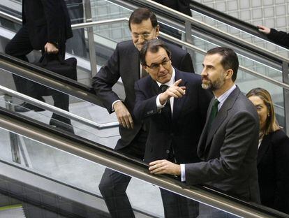El presidente del Gobierno, Mariano Rajoy, el presidente de la Generalitat de Cataluña, Artur Mas, y el Príncipe Felipe en una escalera mecánica a su llegada a la Estación de Girona.