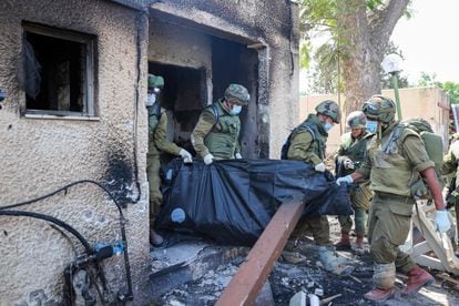 Soldados israelíes retiraban este martes el cuerpo de un compatriota, muerto durante el ataque de milicianos palestinos en el kibutz (cooperativa agrícola) de Kfar Aza, al sur de Israel, en la frontera con la franja de Gaza. 