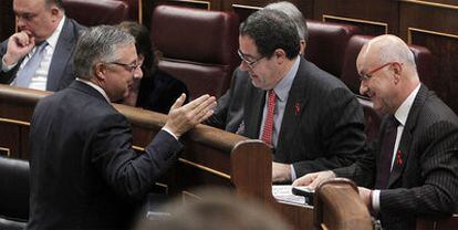 José Blanco (izquierda) charla con los diputados de CiU Pere Macías y Duran Lleida (derecha), ayer en el Congreso.
