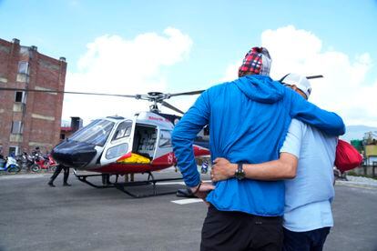 Jim Morrison (izquierda), recibe el cadáver de Hilaree Nelson a su llegada en helicóptero al hospital de Katmandú (Nepal), este viernes. 