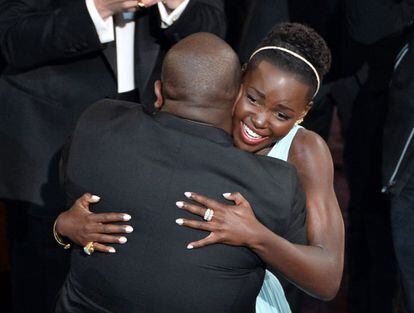 La actriz Lupita Nyong'o (R), ganadora del Oscar a la mejor actriz de reparto' por '12 años de esclavitud', abraza al director y productor del filme, Steve McQueen.