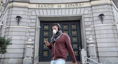 FILE PHOTO: A man wears a protective face mask as he walks past Banco de Espana (Bank of Spain), amidst concerns over coronavirus outbreak, in Barcelona, Spain March 14, 2020. REUTERS/Nacho Doce/File Photo