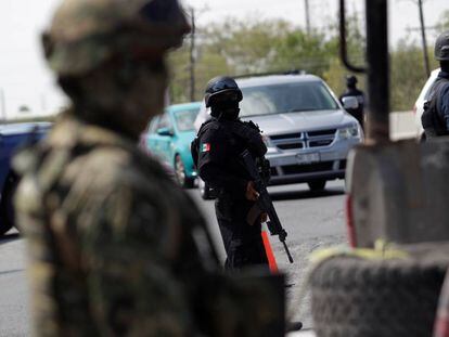 Los agentes de policía estatal y militares mexicanos vigilan en un puesto de control en las de Tamaulipas, México.