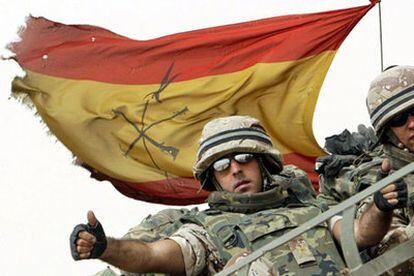 Un legionario español saluda desde el vehículo que le transporta antes de cruzar la frontera entre Irak y Kuwait, cerca de Safwan.