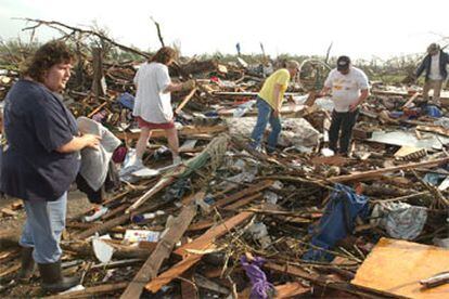 Una familia de Kansas inspecciona lo que queda de su casa, destrozada por un tornado, en Kansas.