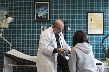 El médico Xosé María Dios toma la tensión a una joven en el centro de salud de Outes.