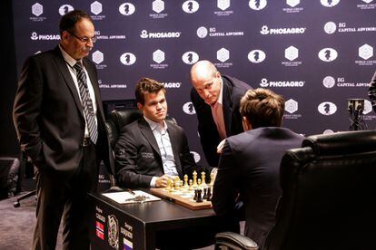 El actor Woody Harrelson hace la jugada inaugural de Carlsen ante Kariakin, junto al árbitro Nikolópulos
