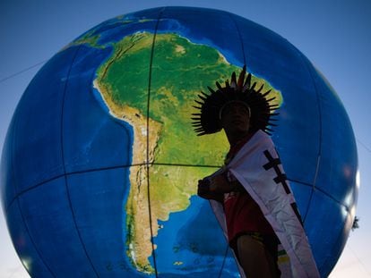 Un indígena brasileño frente a un globo terráqueo hinchable, durante una protesta en Brasilia.