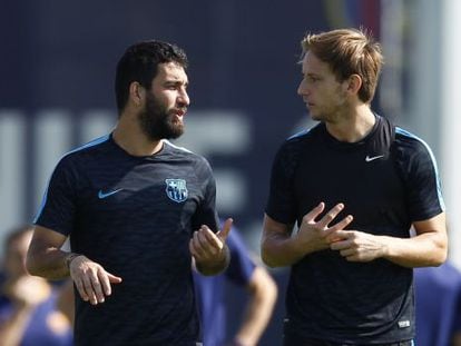 Arda Turan conversa con Rakitic en un entrenamiento del Barça.