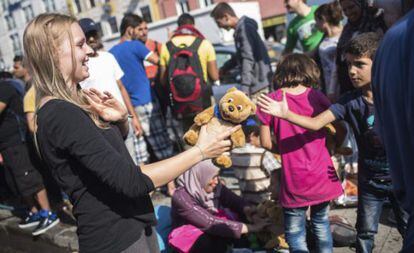 Una trabajadora de la iniciativa 'Ayuda a los Refugiados en Múnich' entrega un oso de peluche.